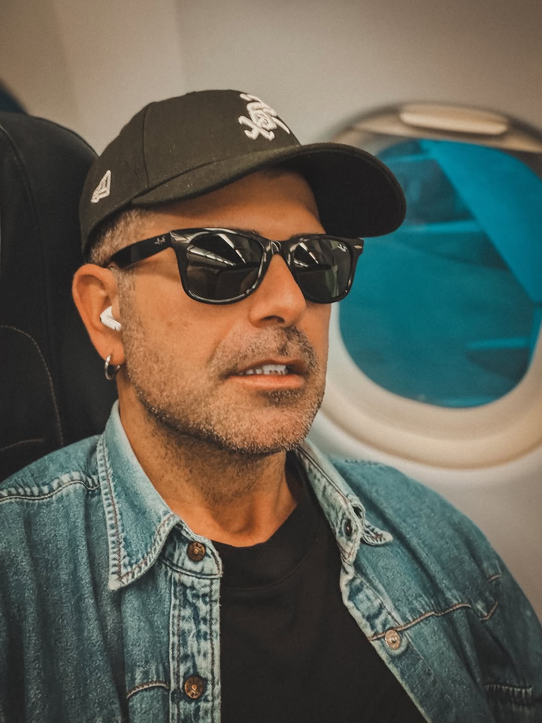 Mirko Boni wearing sunglasses on an airplane.